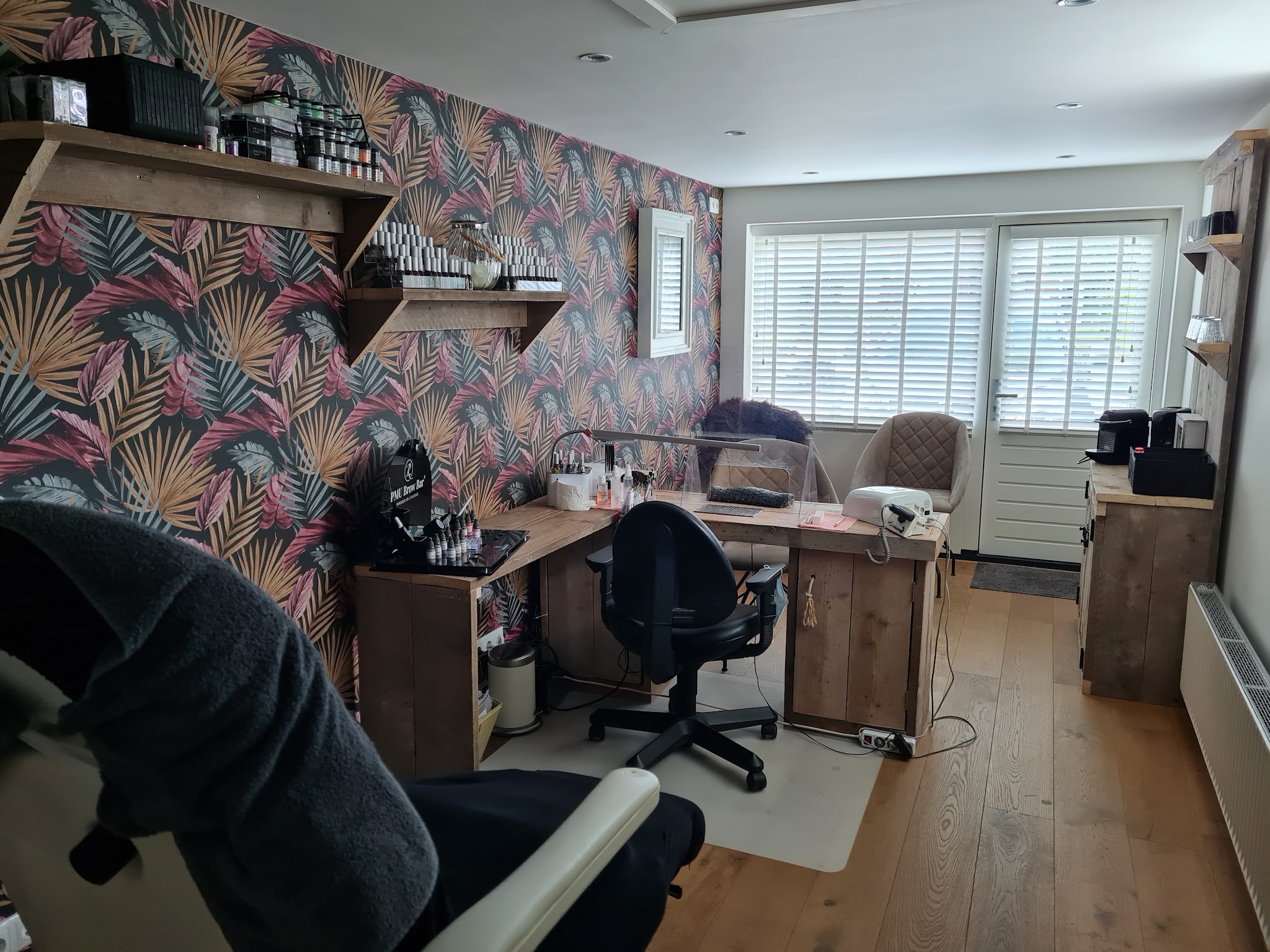 De werkplek voor nagels met het bureau, de lampen en de planken met producten